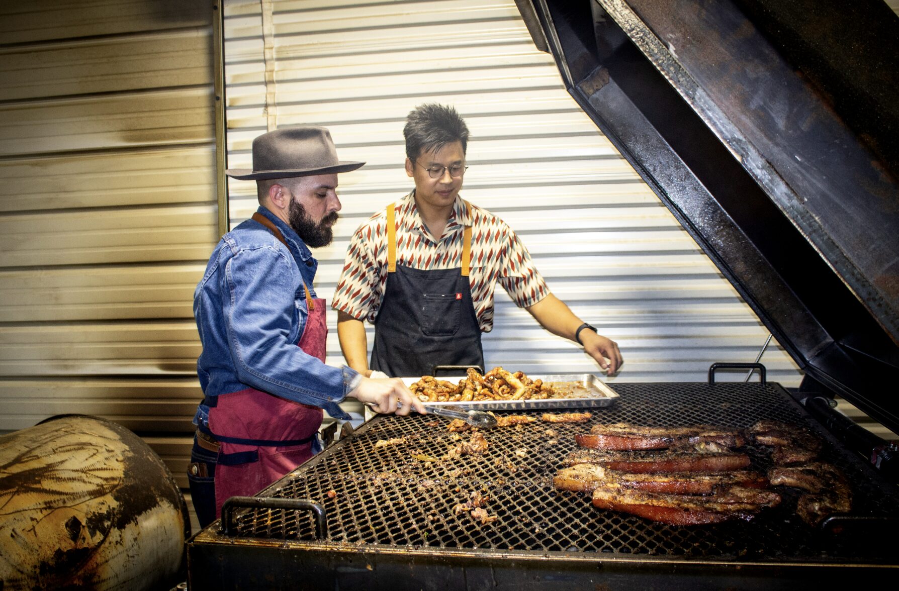 Southern pitmasters Hector Garate and Don Nguyen barbecuing together.